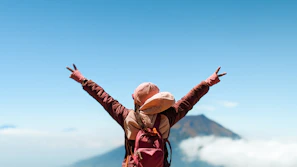 A person standing on top of a mountain with their arms outstretched