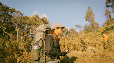 A woman with a backpack and a cell phone