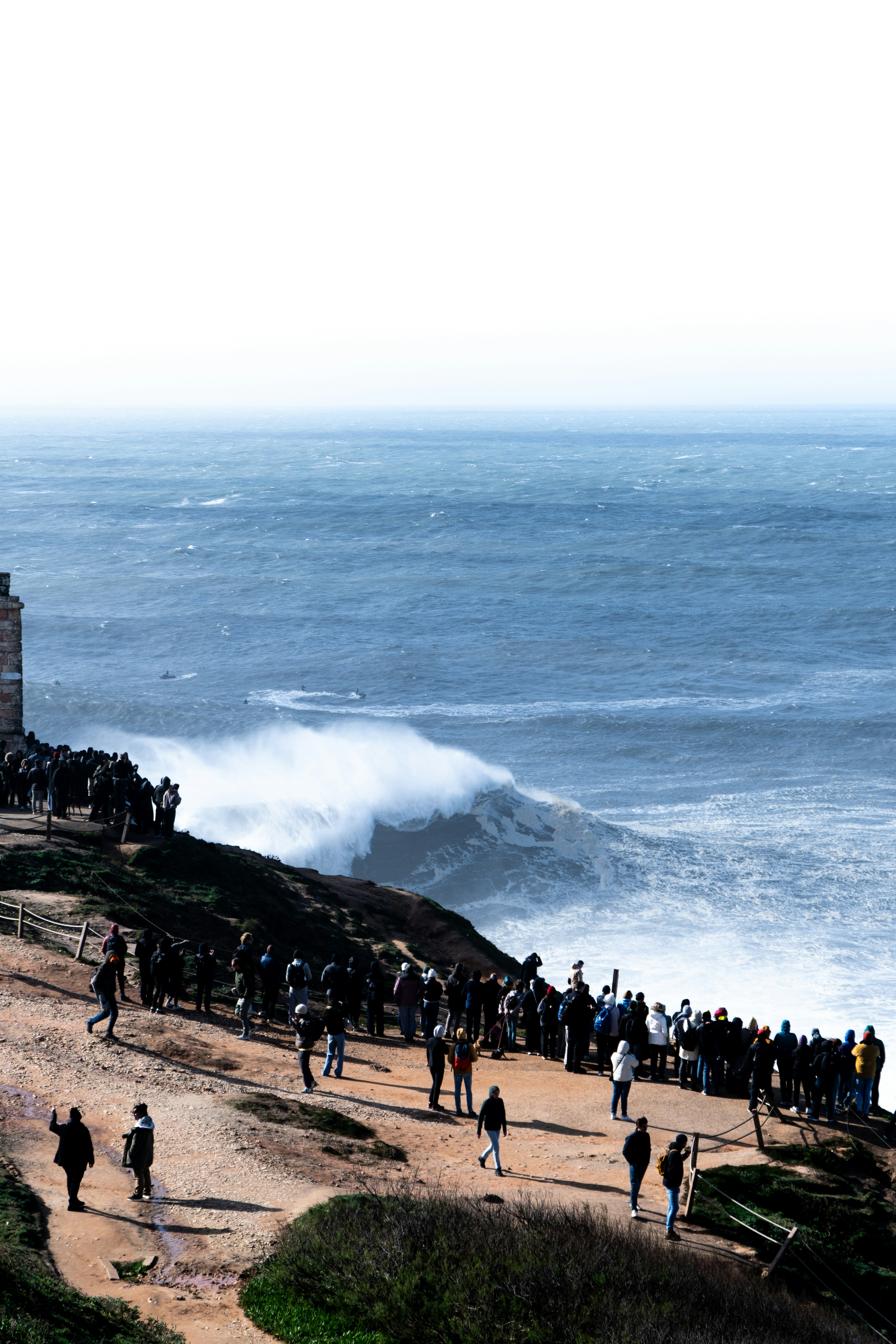 A group of people standing on top of a beach next to the ocean