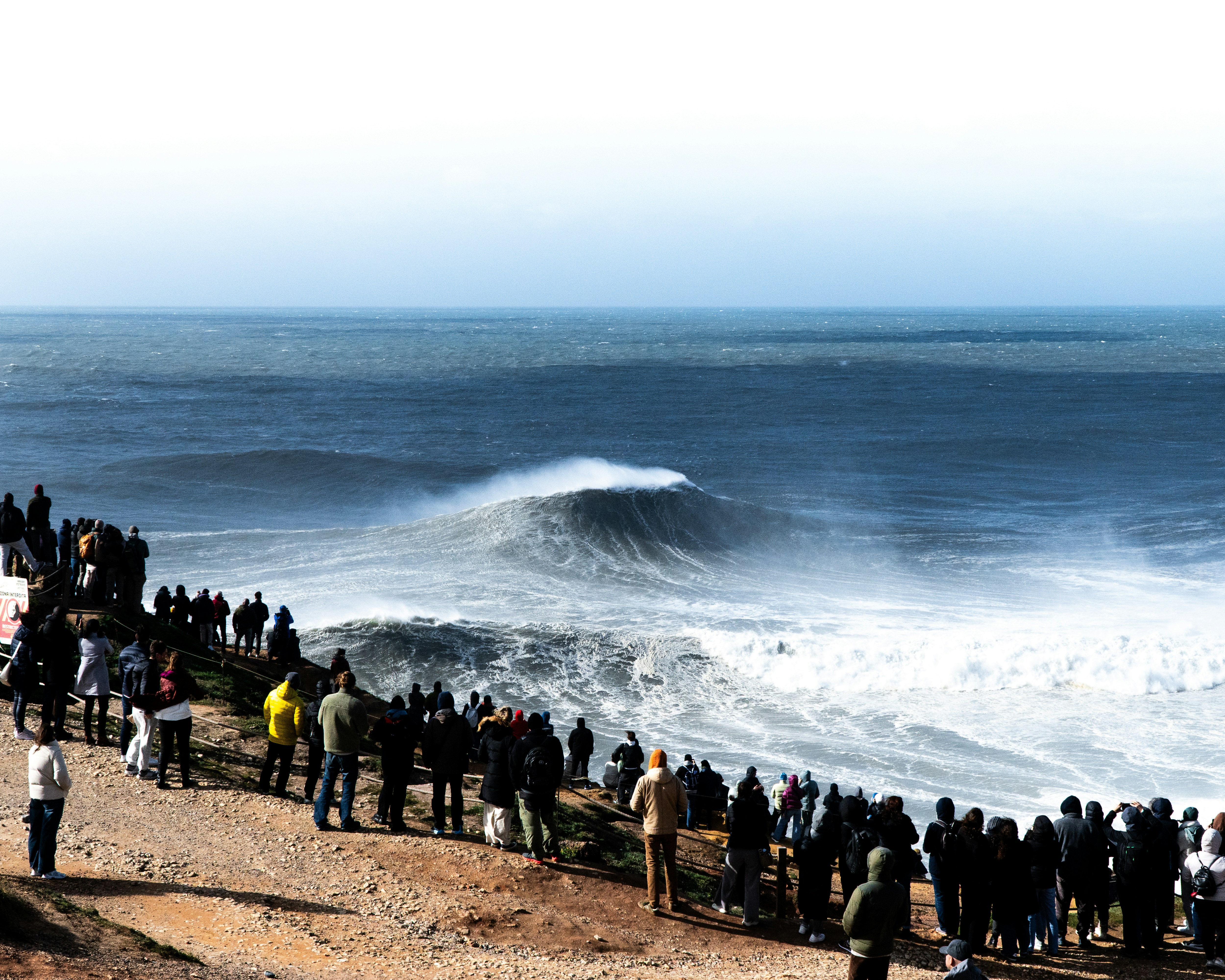 A group of people standing on a beach next to the ocean