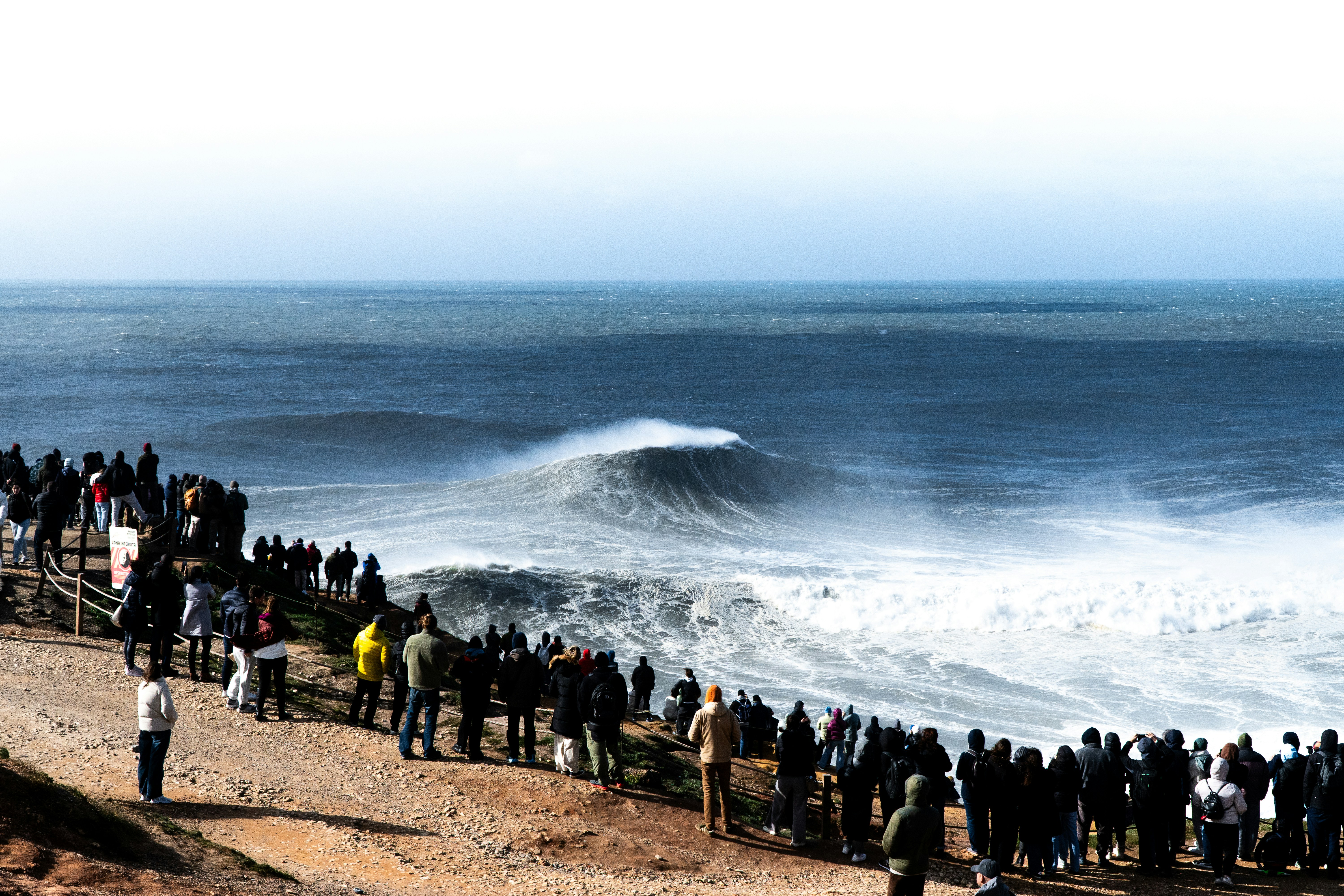 A group of people standing on a beach next to the ocean