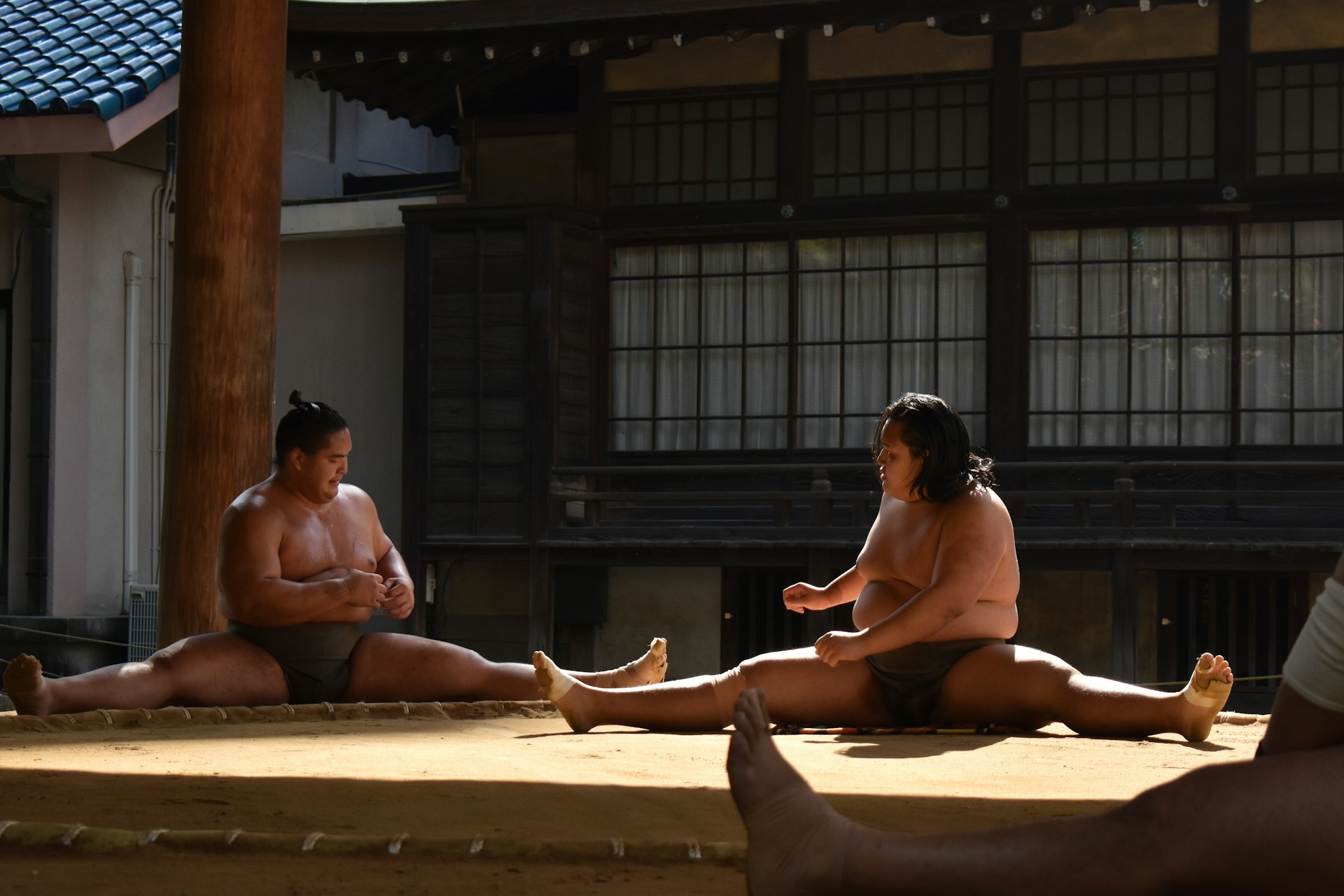 A group of people sitting on the ground in front of a building
