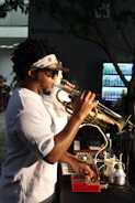 A man with dreadlocks playing a trumpet