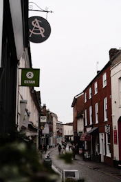 A narrow street with a sign hanging from the side of it