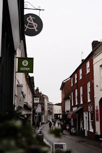 A narrow street with a sign hanging from the side of it
