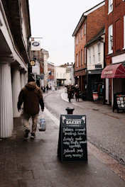 A man walking down a street next to a sidewalk