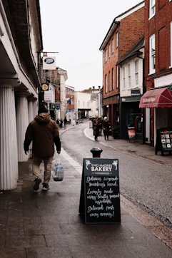 A man walking down a street next to a sidewalk