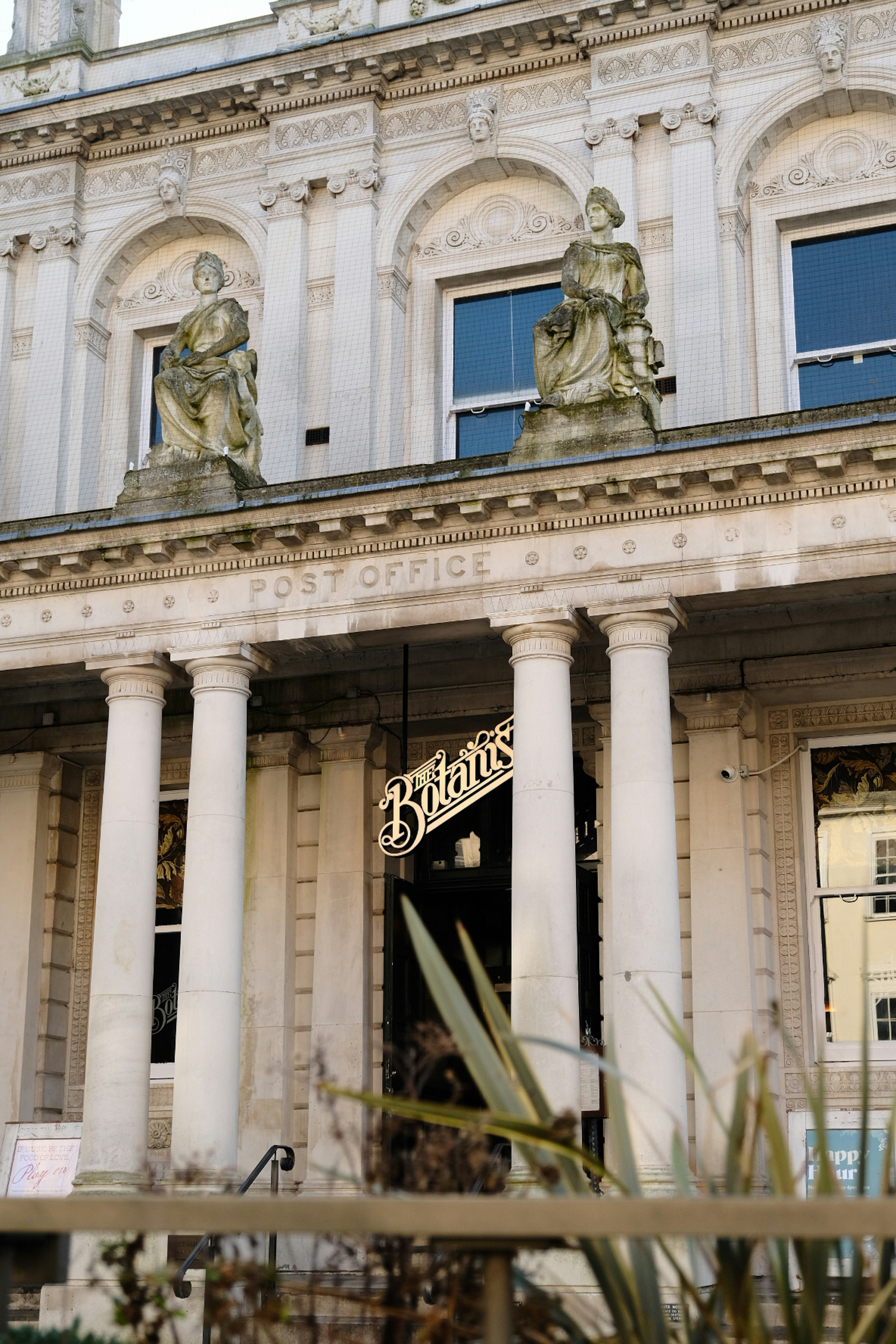 A tall building with statues on top of it