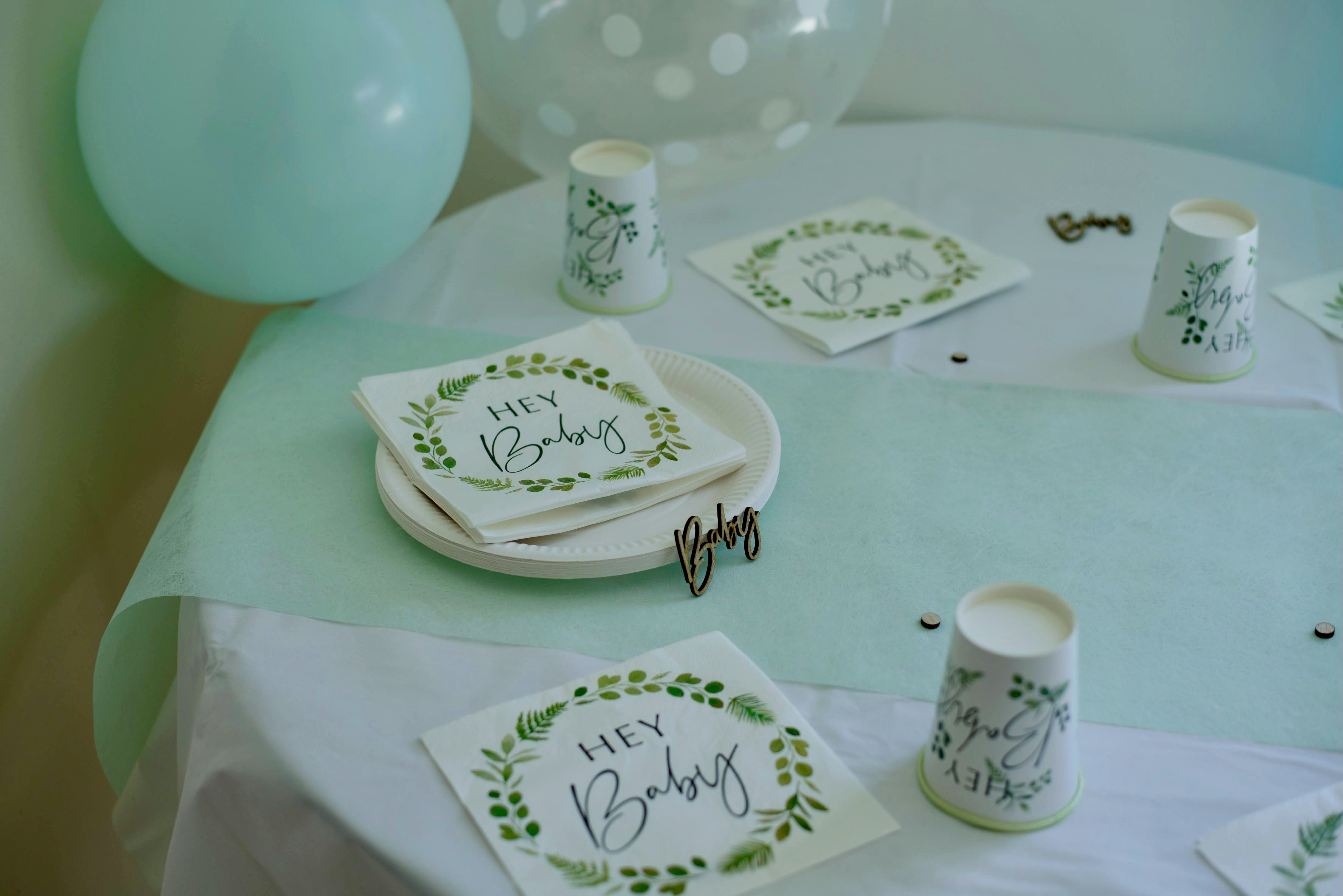 A table topped with plates and cups next to a balloon
