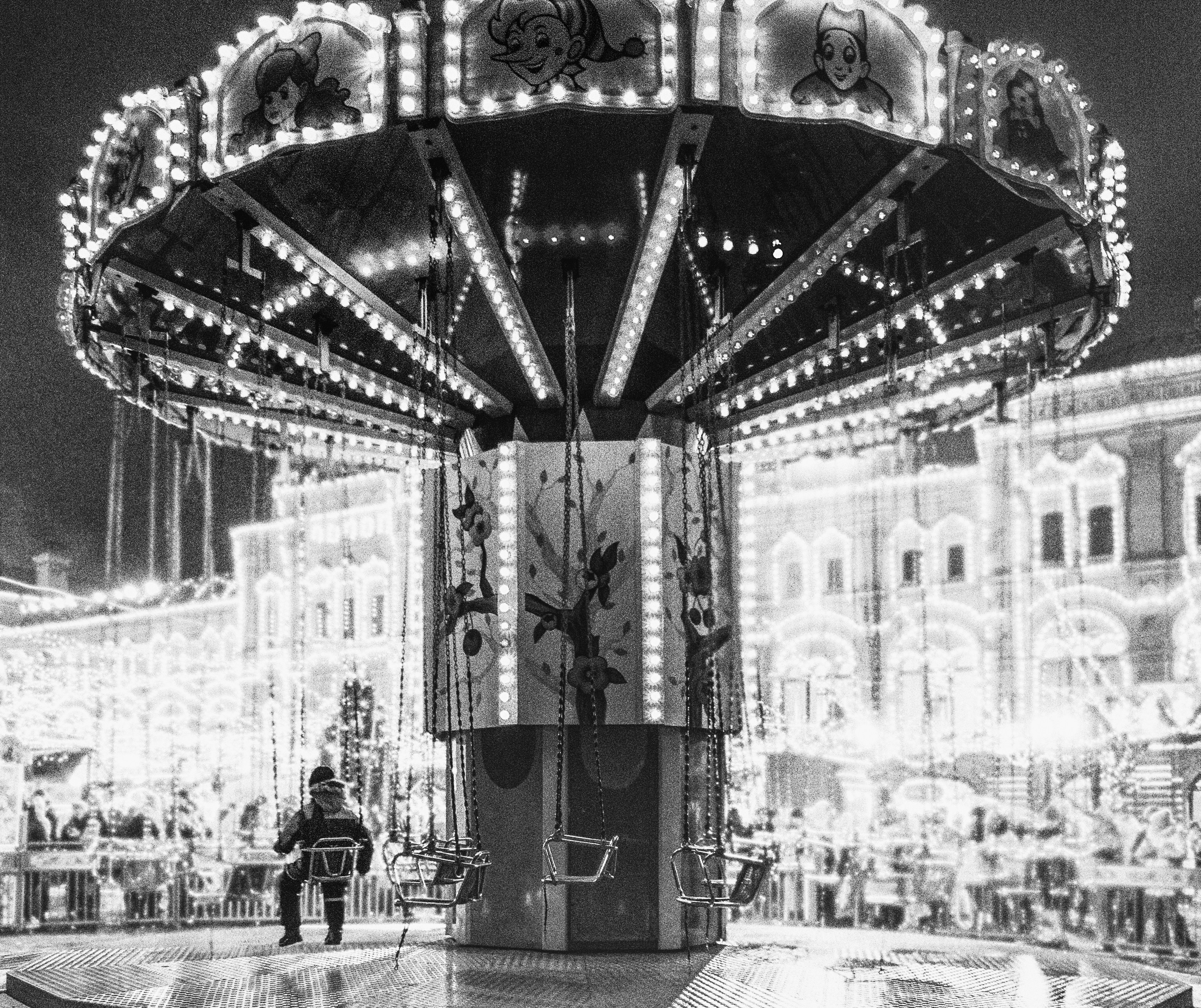A merry go round at night with people walking around