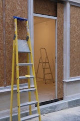 A ladder leaning against a wall next to a window