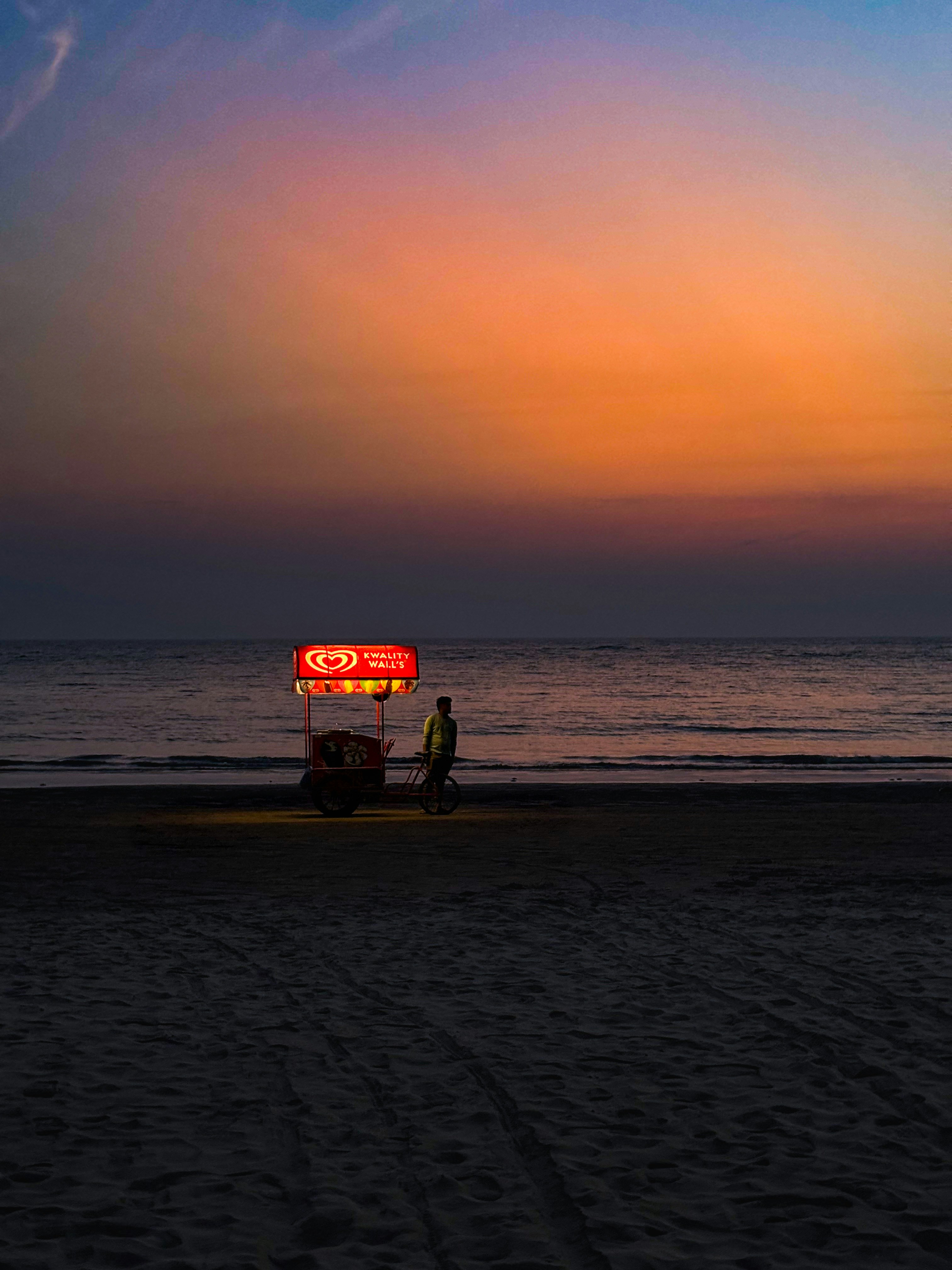 Une enseigne au néon rouge posée au sommet d’une plage de sable