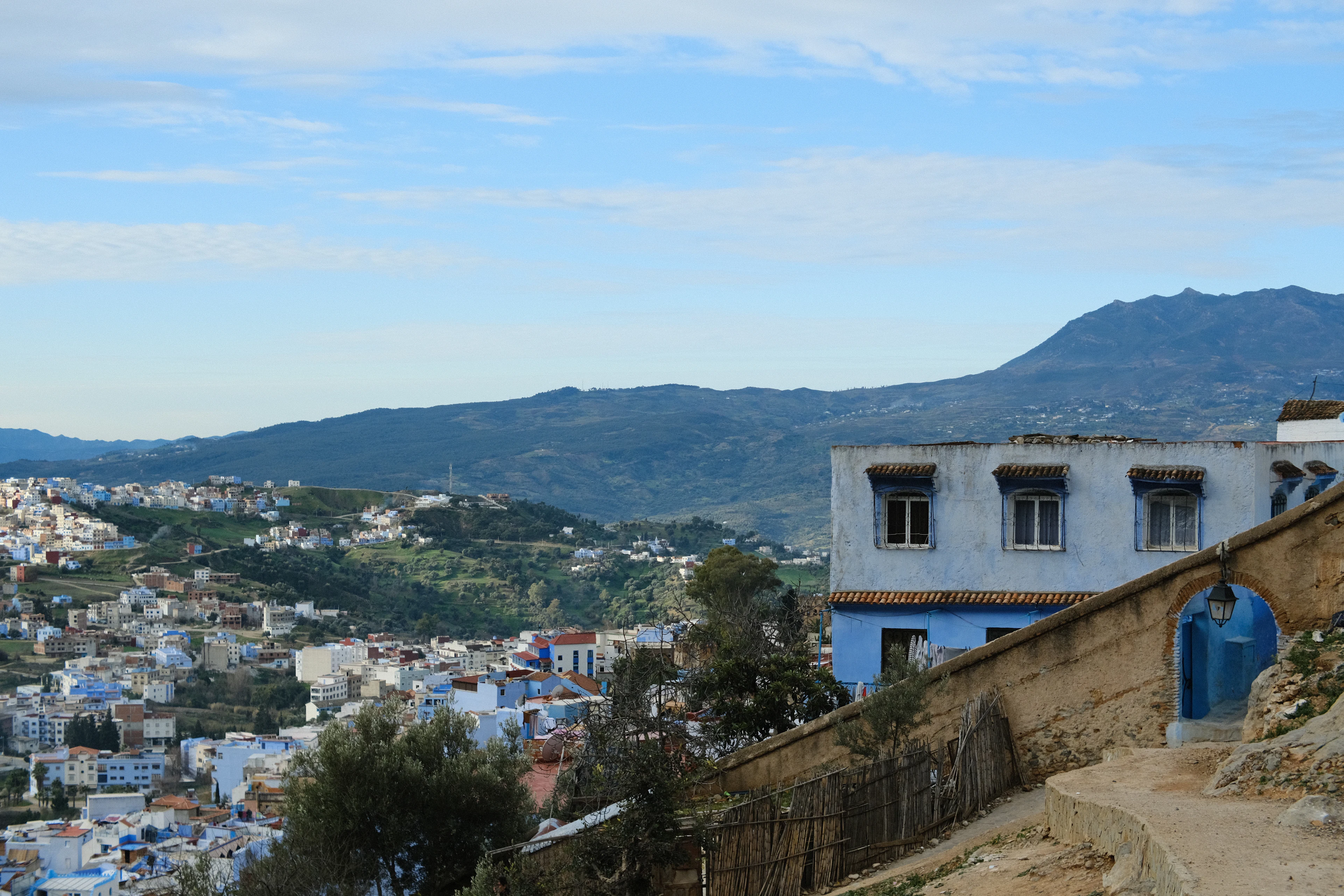 A view over the town of Chefchaouen from the top of a hill, with buildings spread across the slope