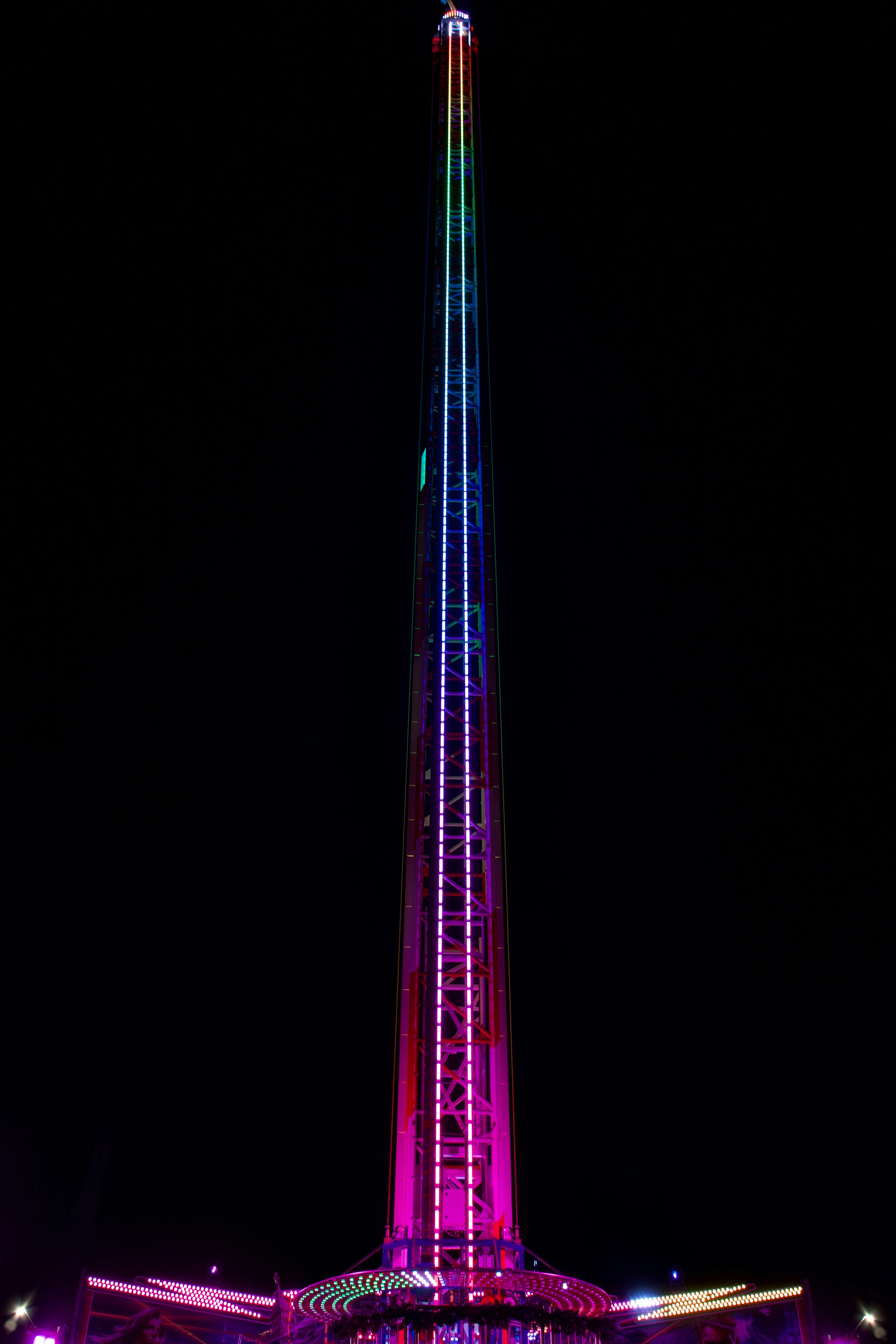 A very tall tower with a very colorful light on it's side