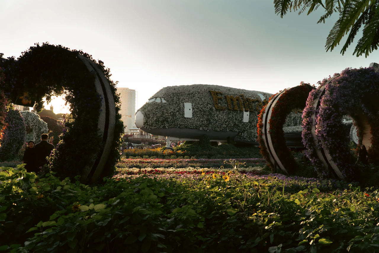 Golden-hour light through the heart-shaped flower arches at Dubai Miracle Garden, with the floral A380 behind