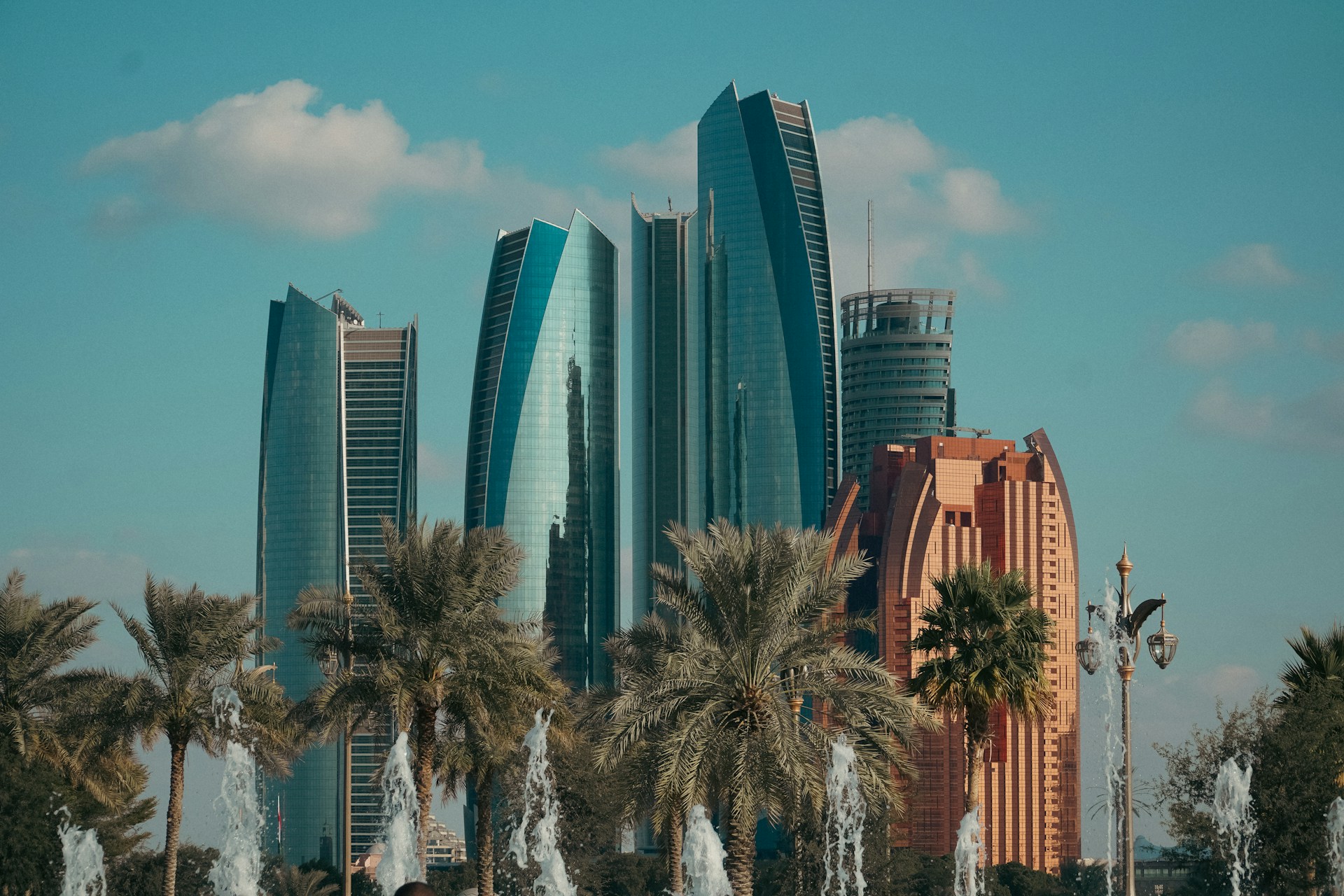 A group of palm trees sitting in front of a tall building