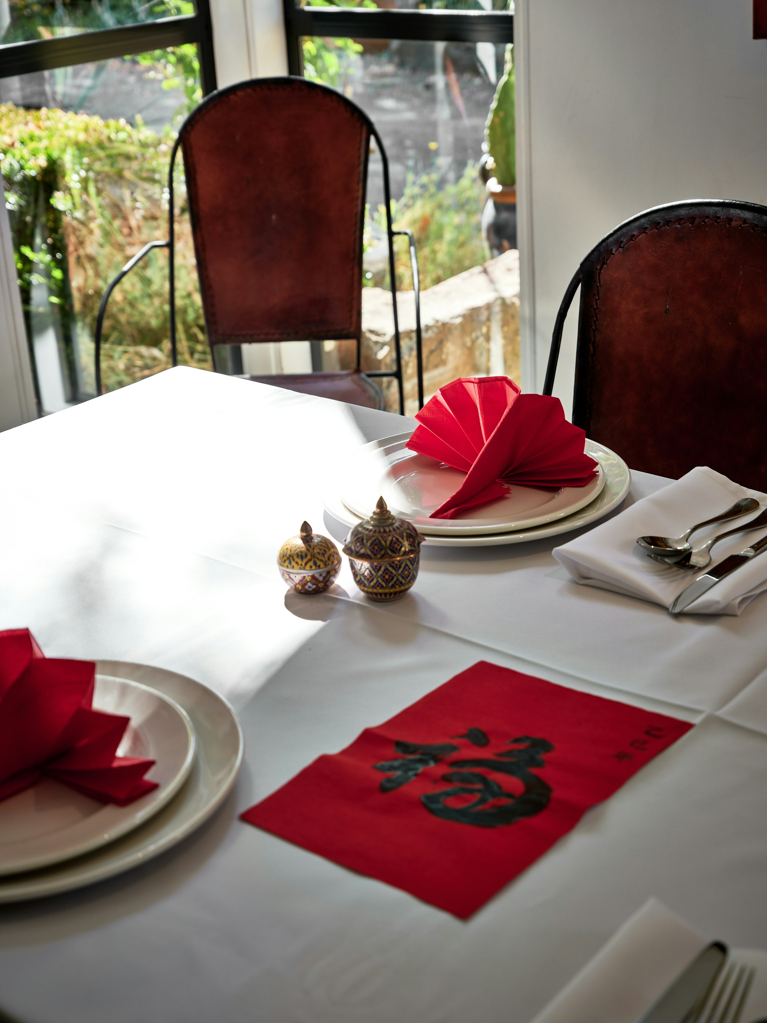 A white table with red napkins and place settings
