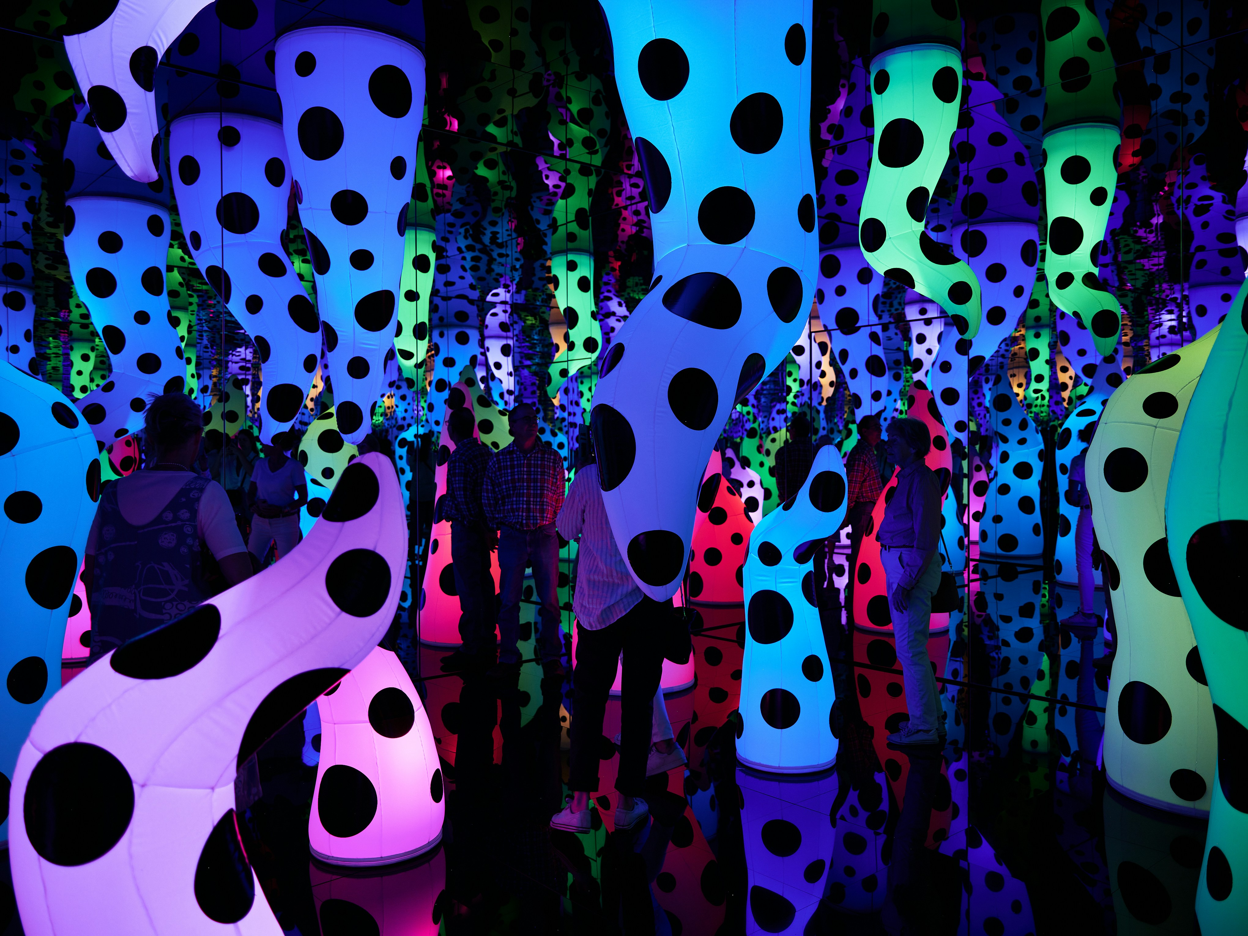 A group of people standing in front of a colorful display