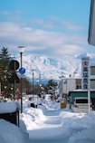A snowy street with a mountain in the background