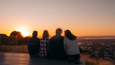 A group of people sitting on top of a hill