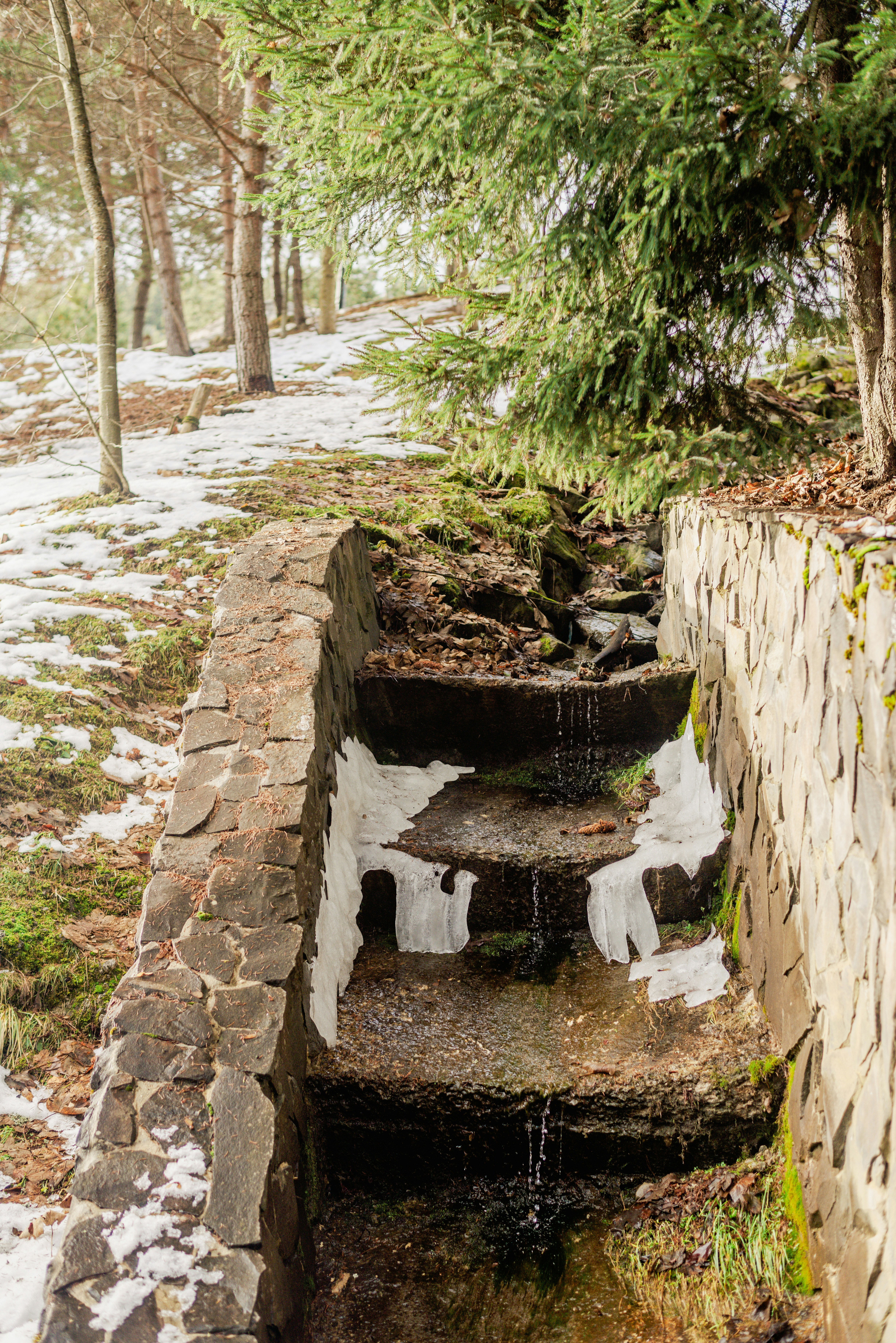 A stone wall with a small waterfall running down it