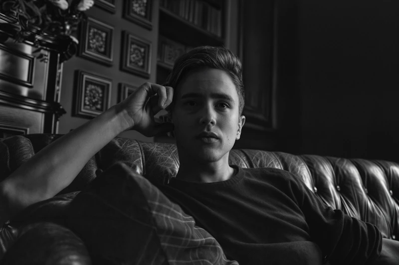 Una foto en blanco y negro de un sugar daddy español en un sofá