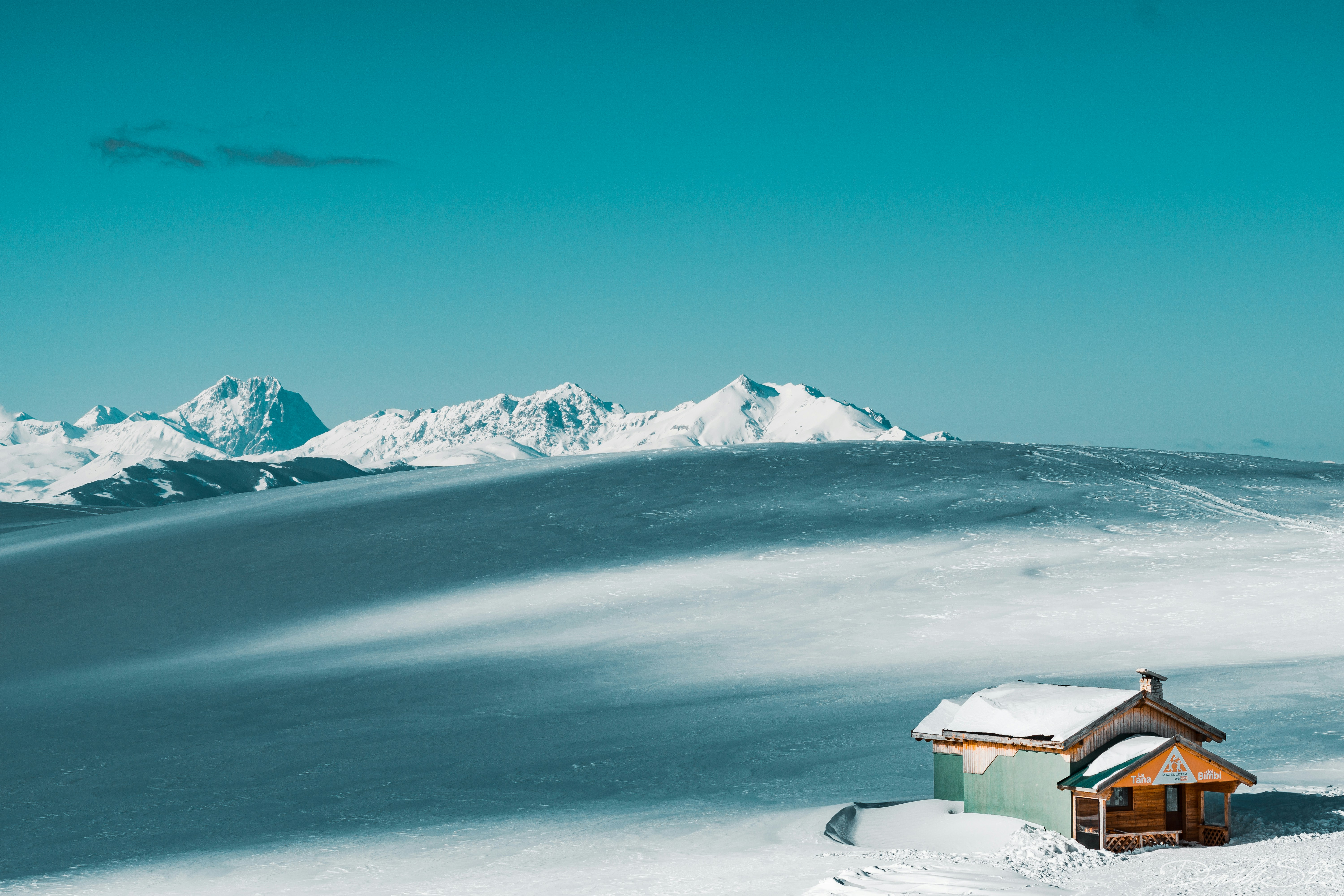 A small house in the middle of a snowy field