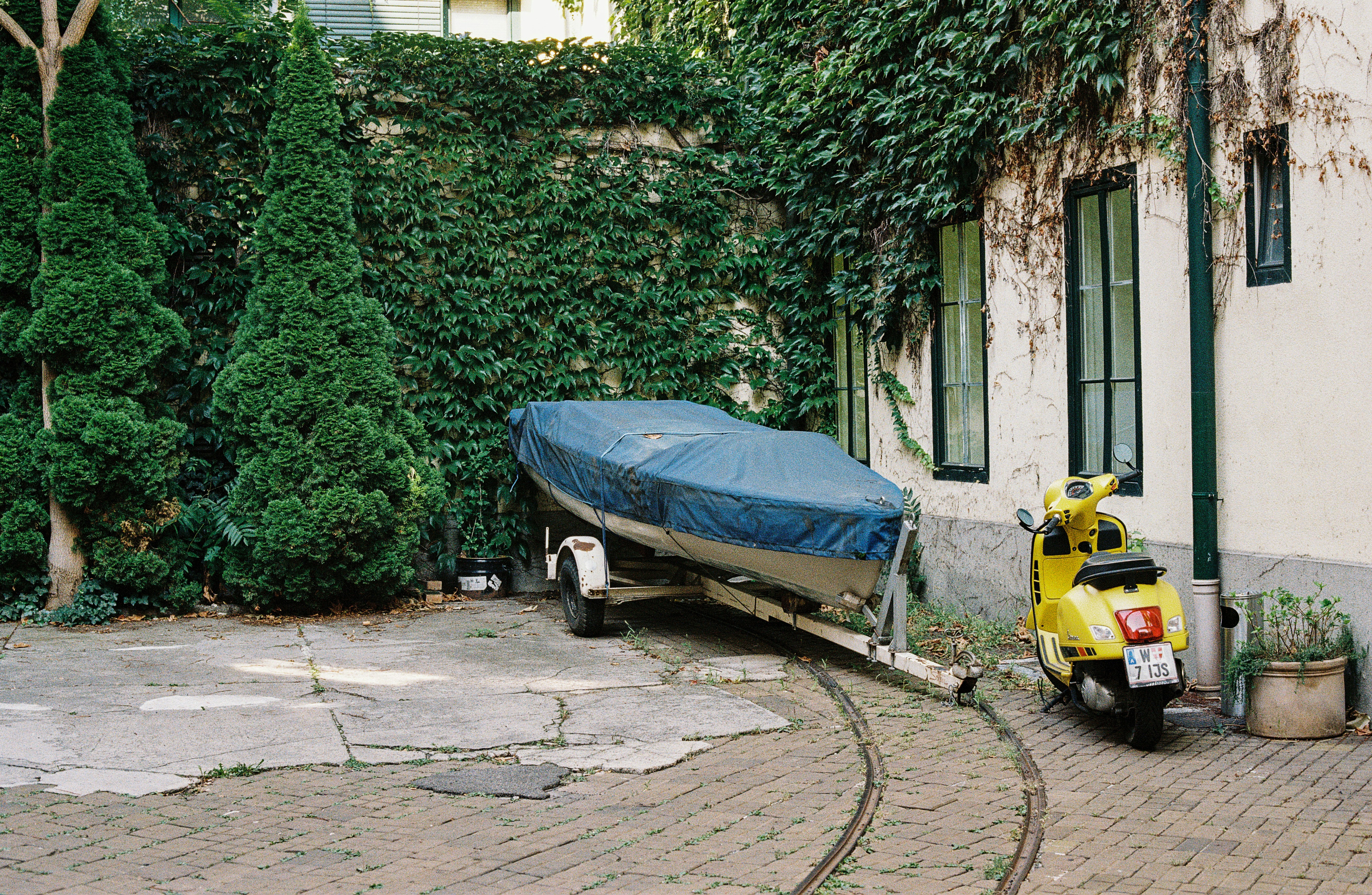 A motor bike parked next to a boat on a trailer