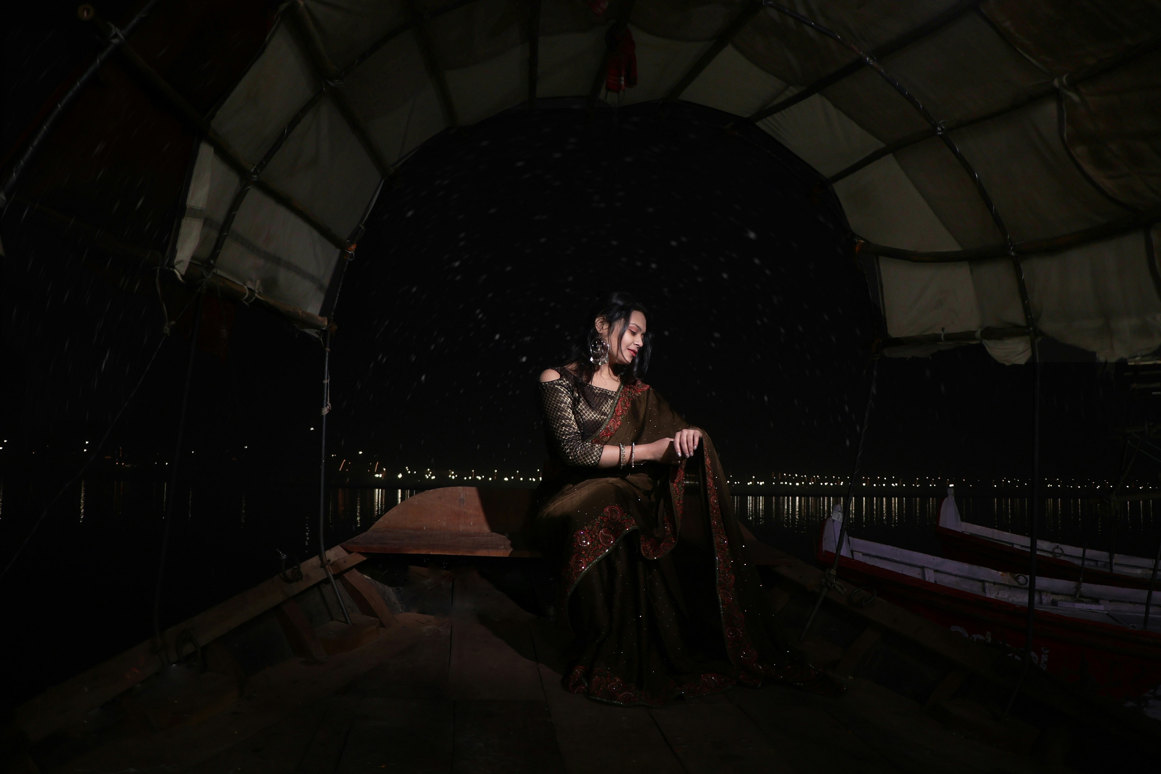 A woman sitting on a bench in the dark