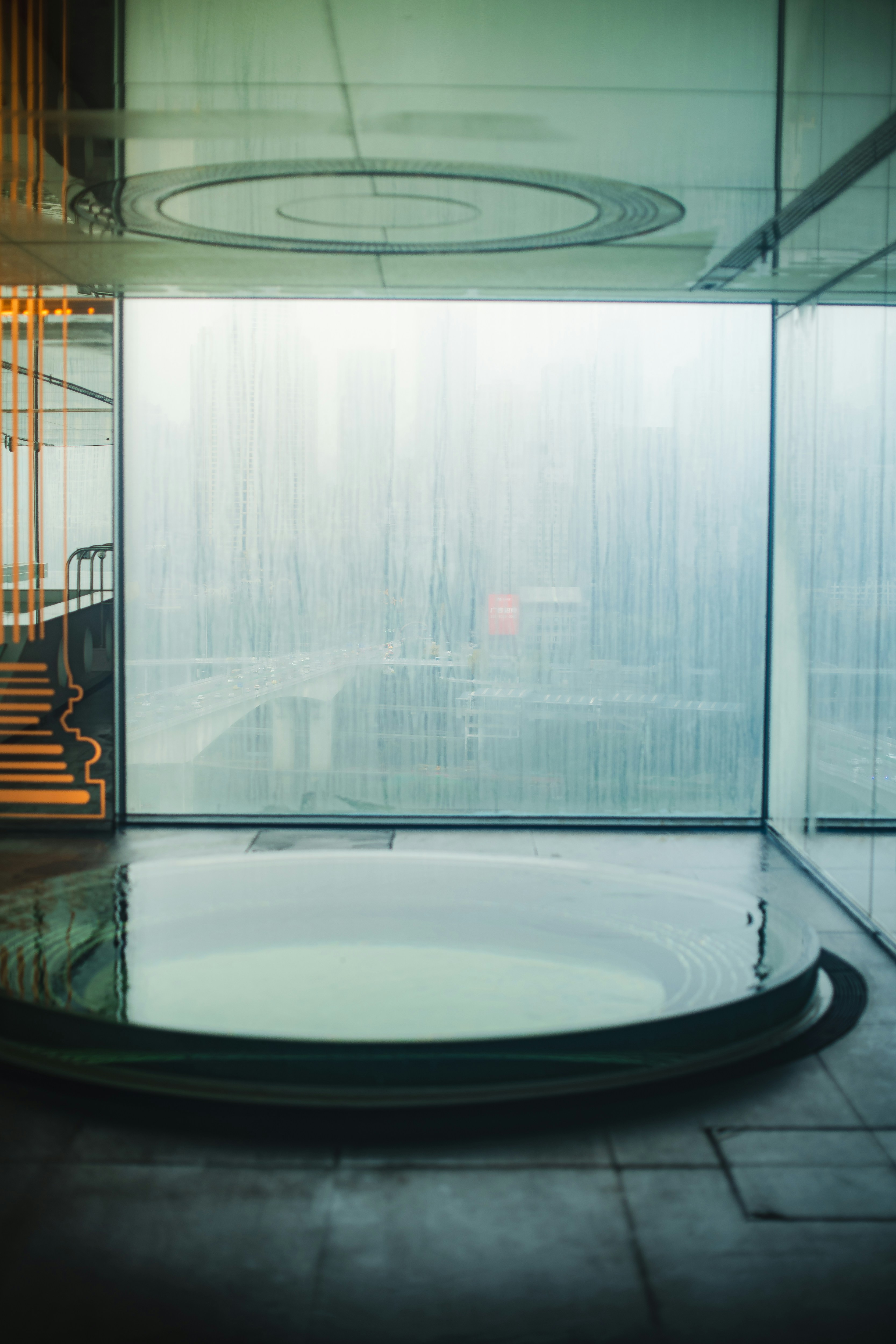 A room with a circular glass table and stairs