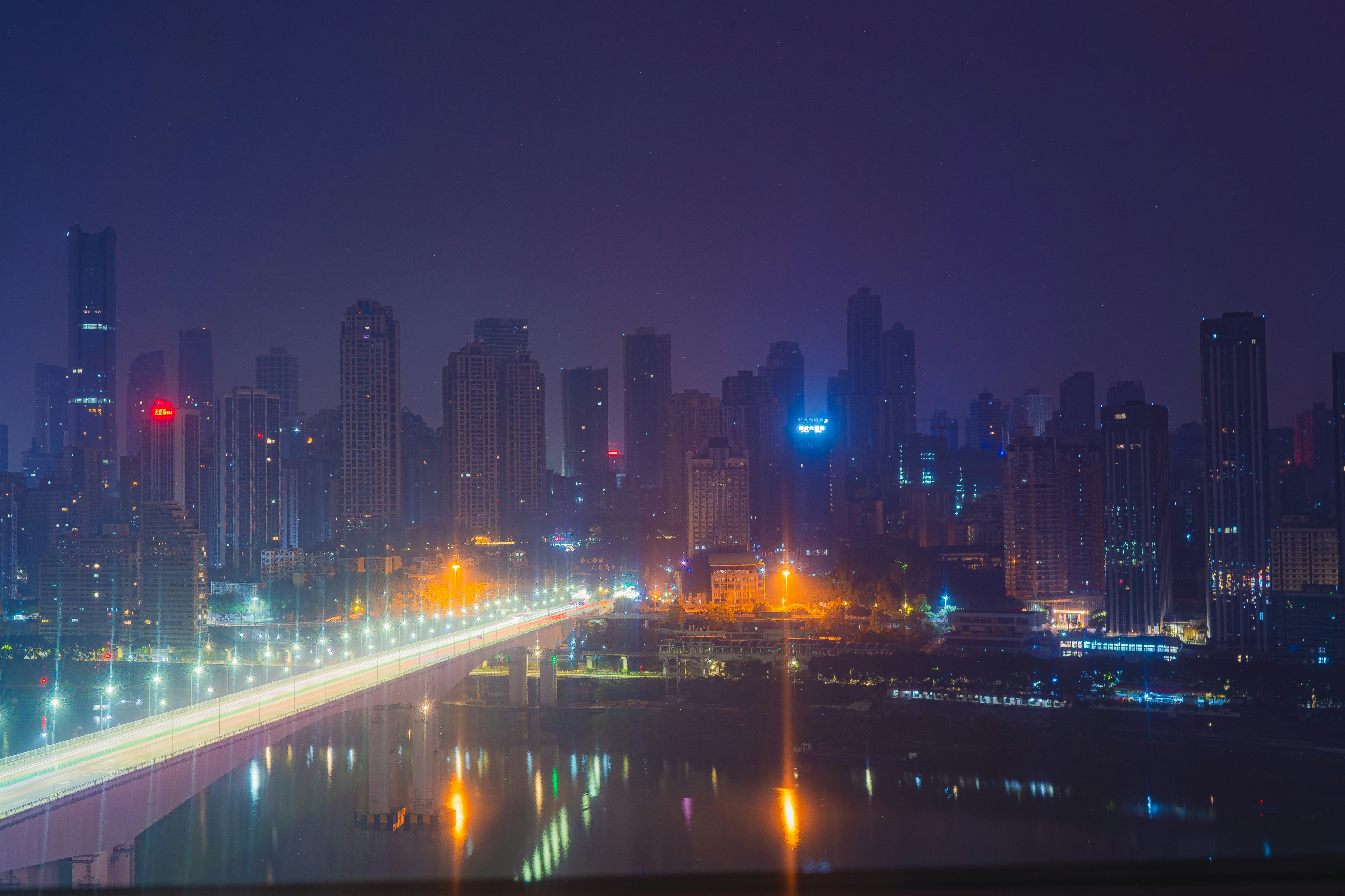 A city skyline at night with lights reflecting in the water