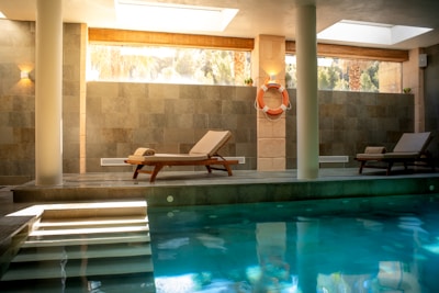 A large swimming pool with a lounge chair next to it