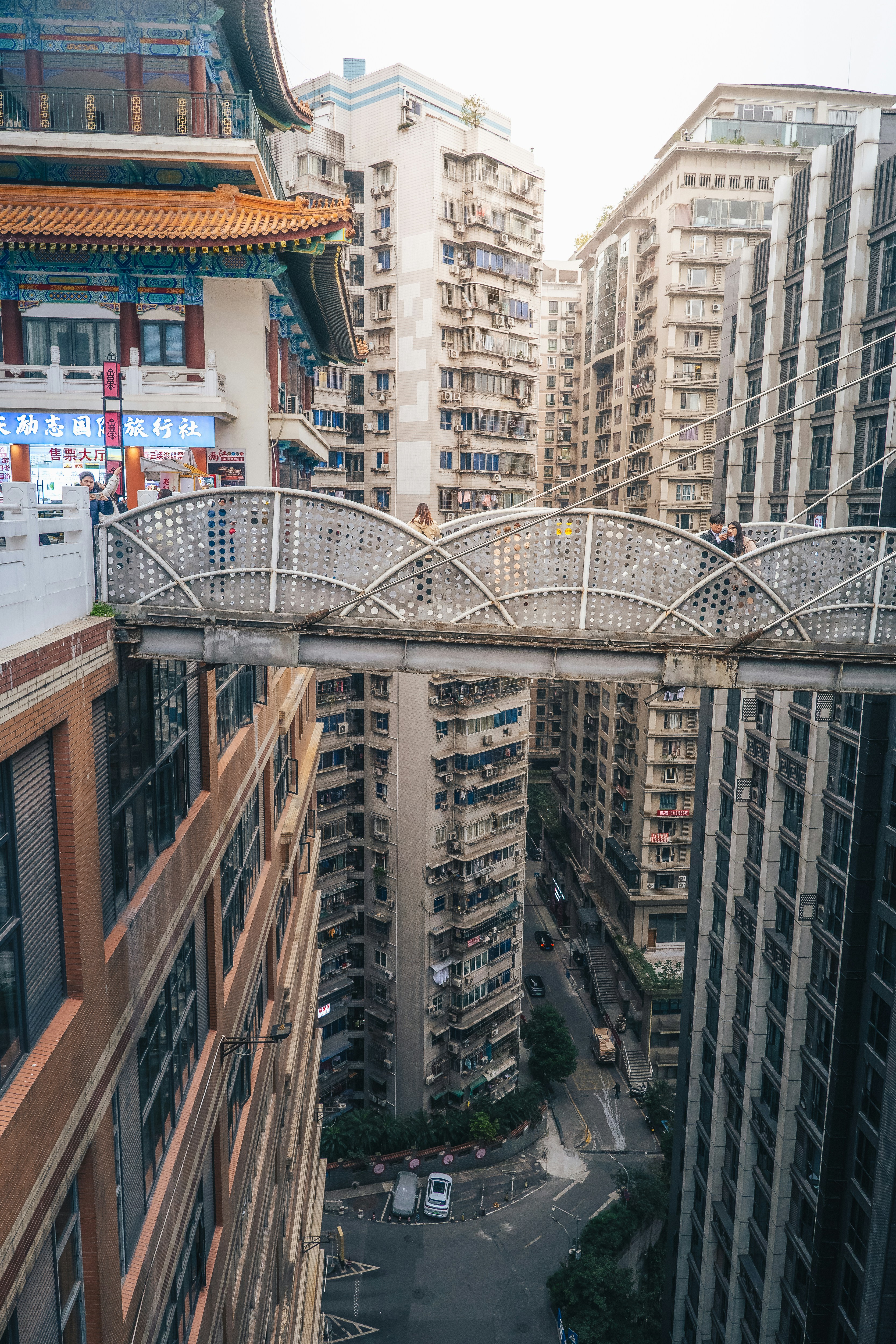 A bridge over a city street with tall buildings
