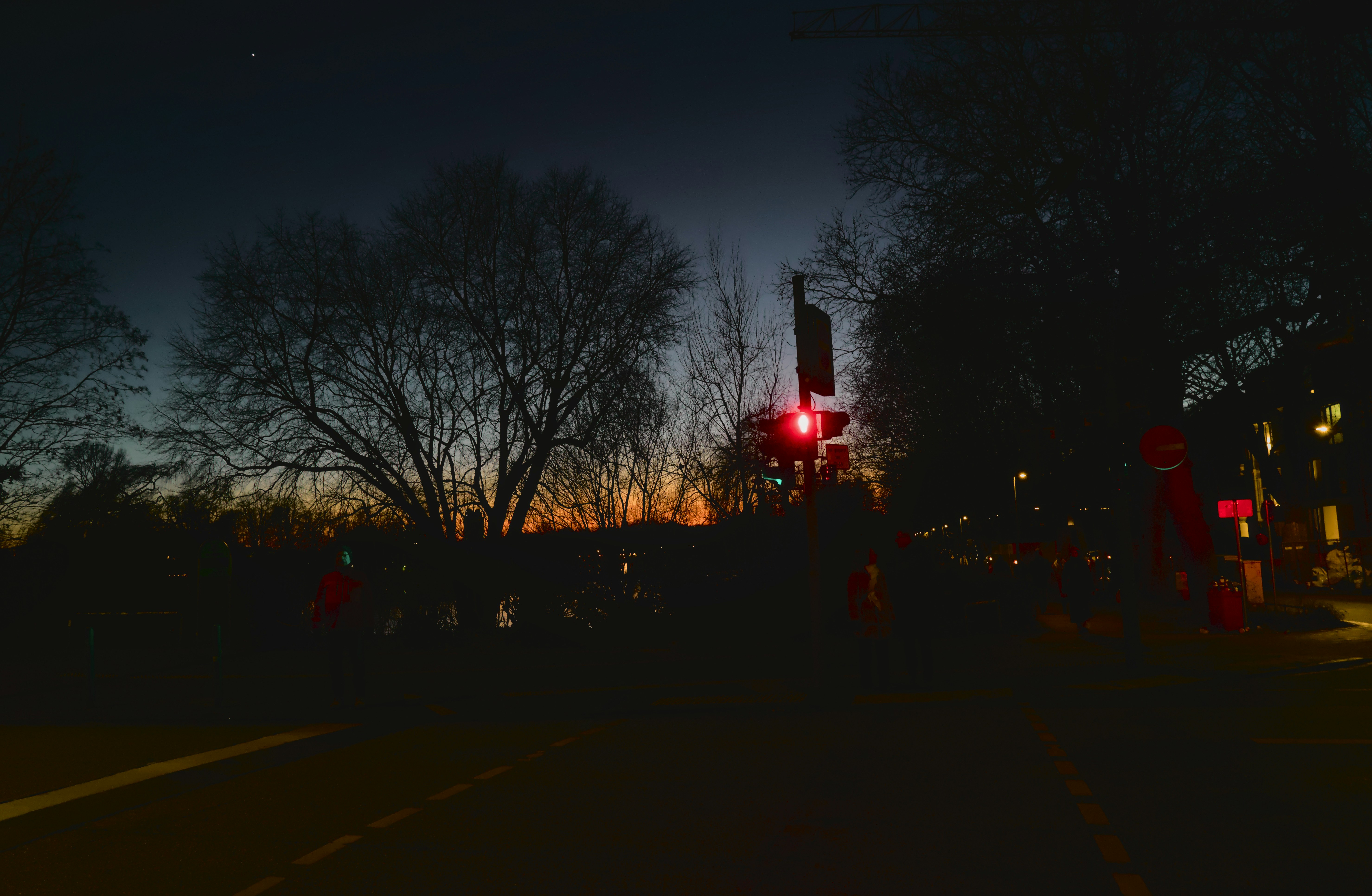 A red traffic light sitting on the side of a road