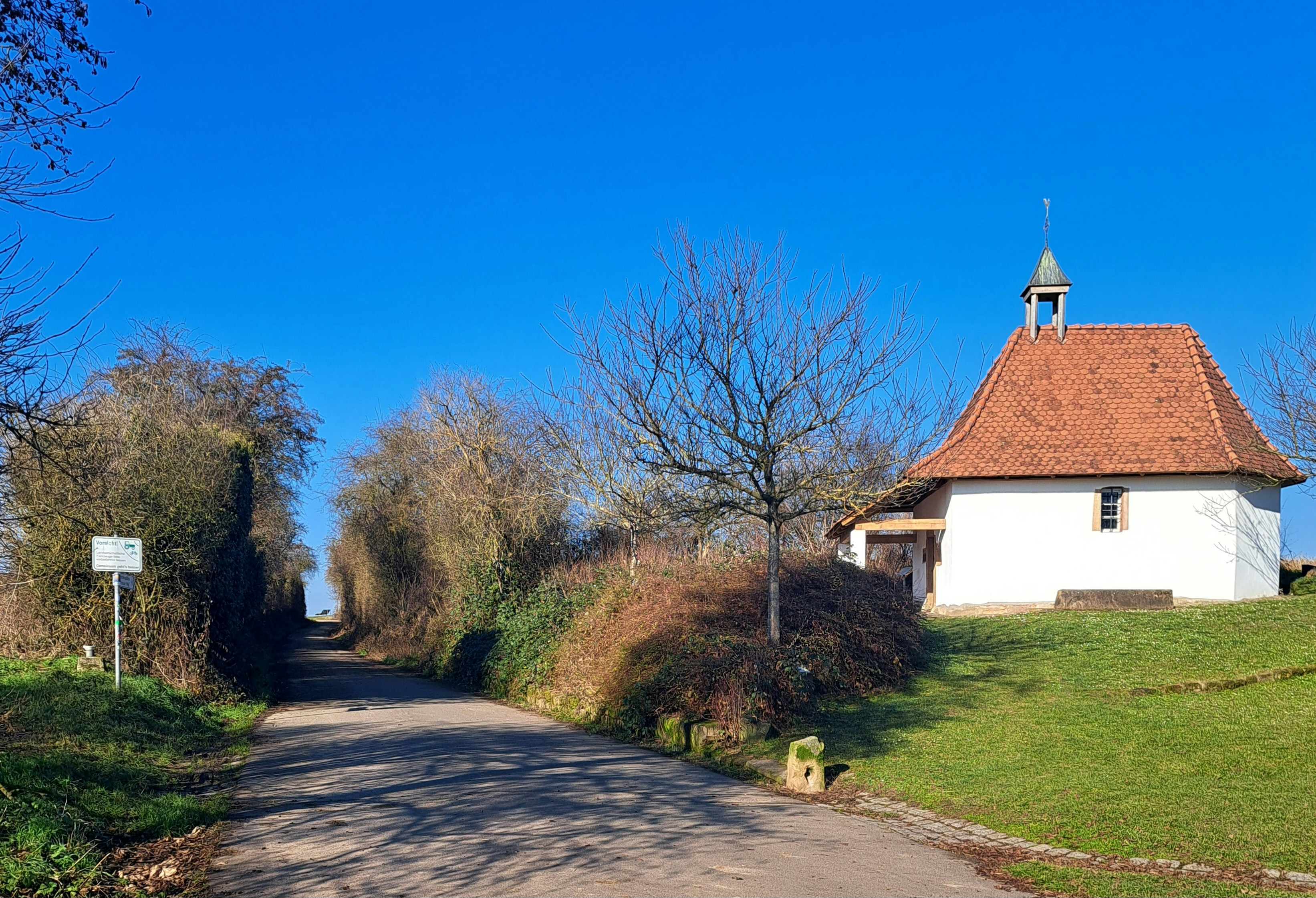 A small white house sitting on the side of a road