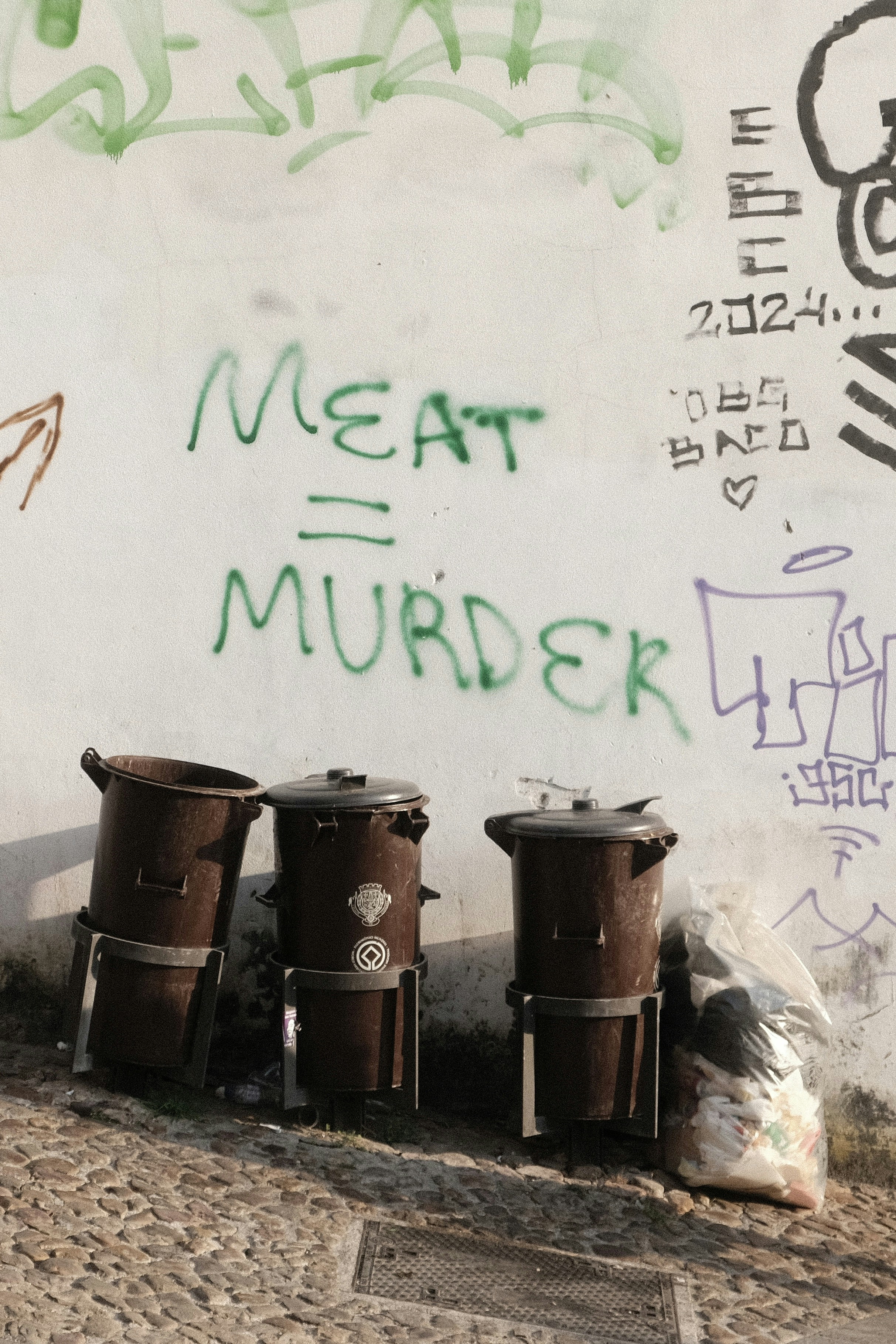 Un groupe de seaux assis à côté d’un mur avec des graffitis dessus