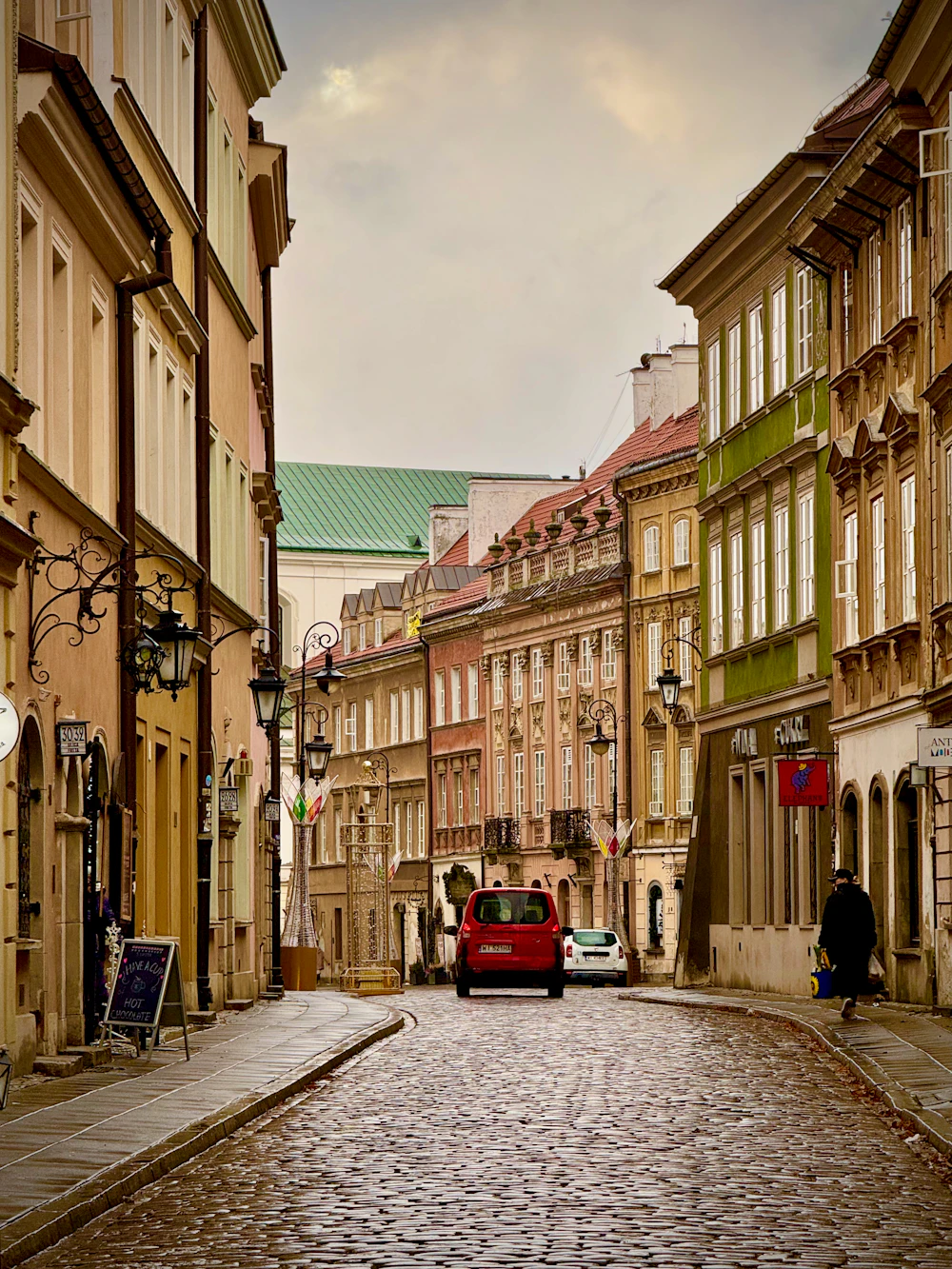 Cobblestone street lined with colourful historic houses in Warsaw Old Town