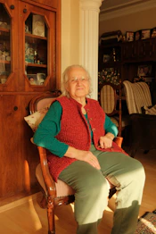 An older woman sitting in a chair in a living room