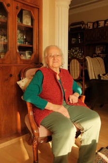 An older woman sitting in a chair in a living room
