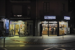 A street corner at night with a store front