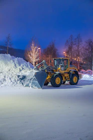 A snow plow in the middle of a snowy field