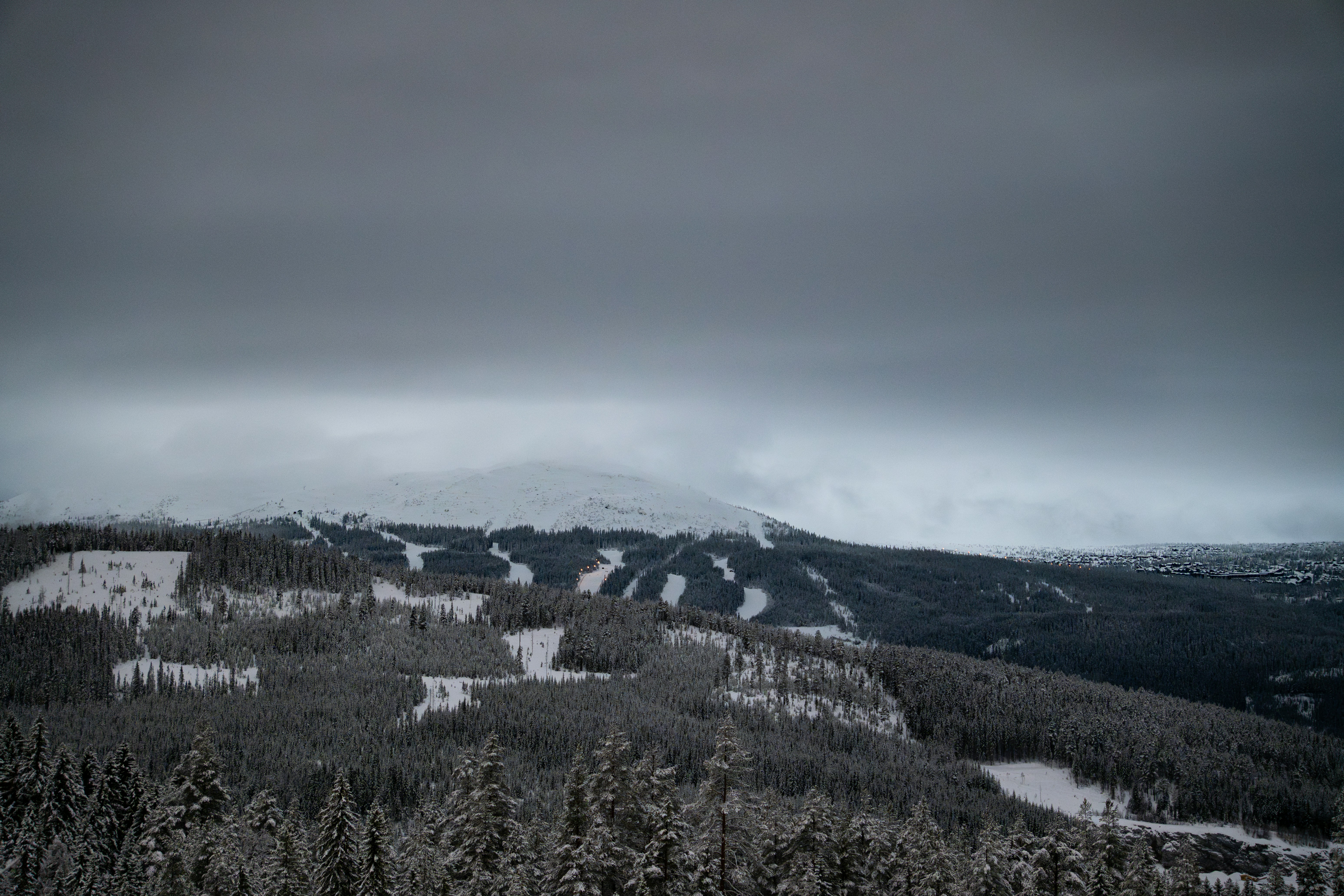 A mountain covered in snow under a cloudy sky