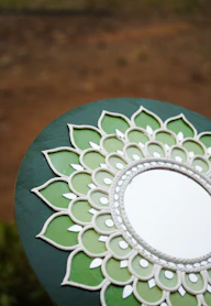 A mirror sitting on top of a wooden table