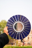 A person holding a blue plate with a mirror on it