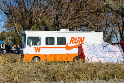 An orange and white food truck parked in a field