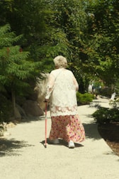 A woman walking down a path with a cane