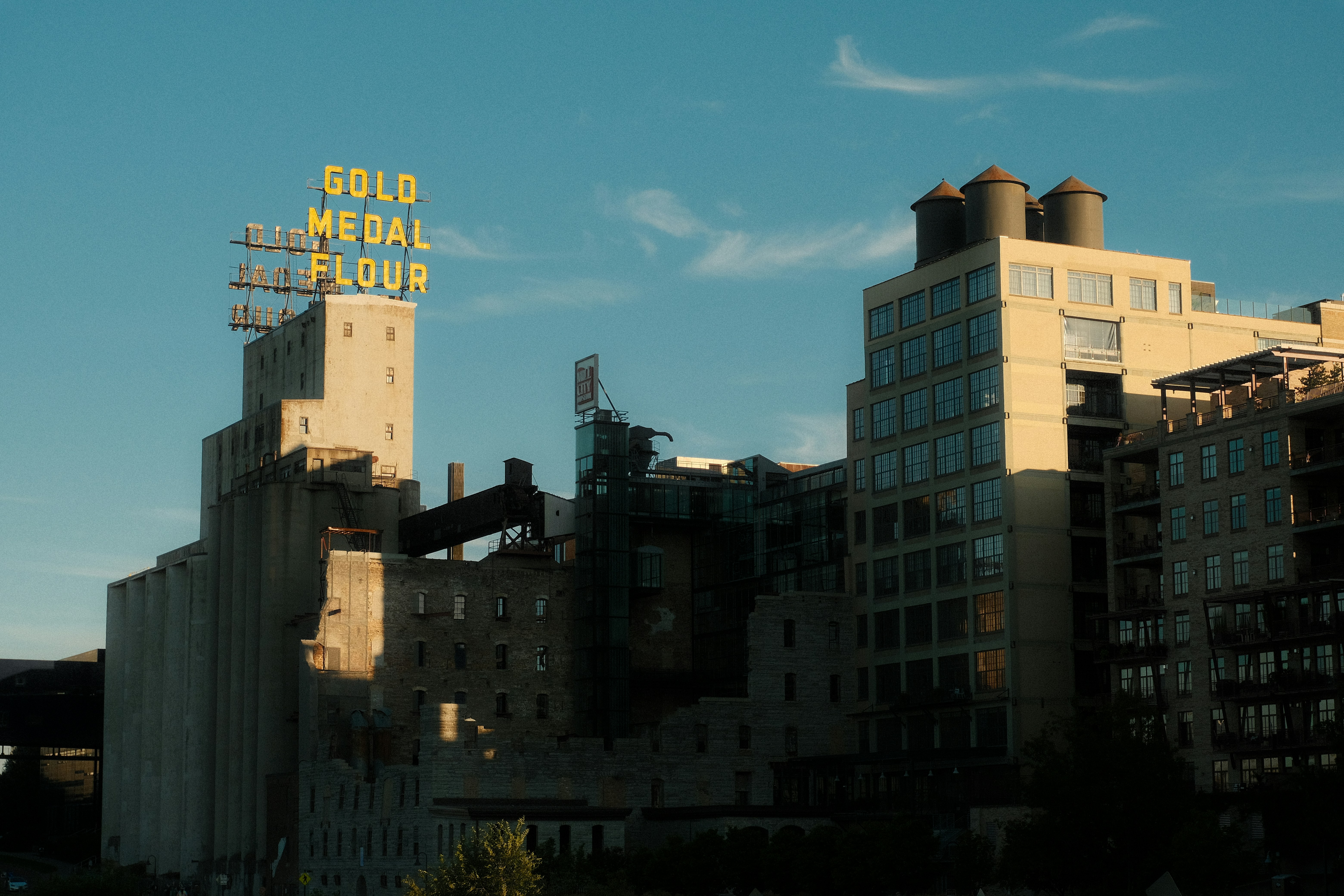 A tall building with a neon sign on top of it