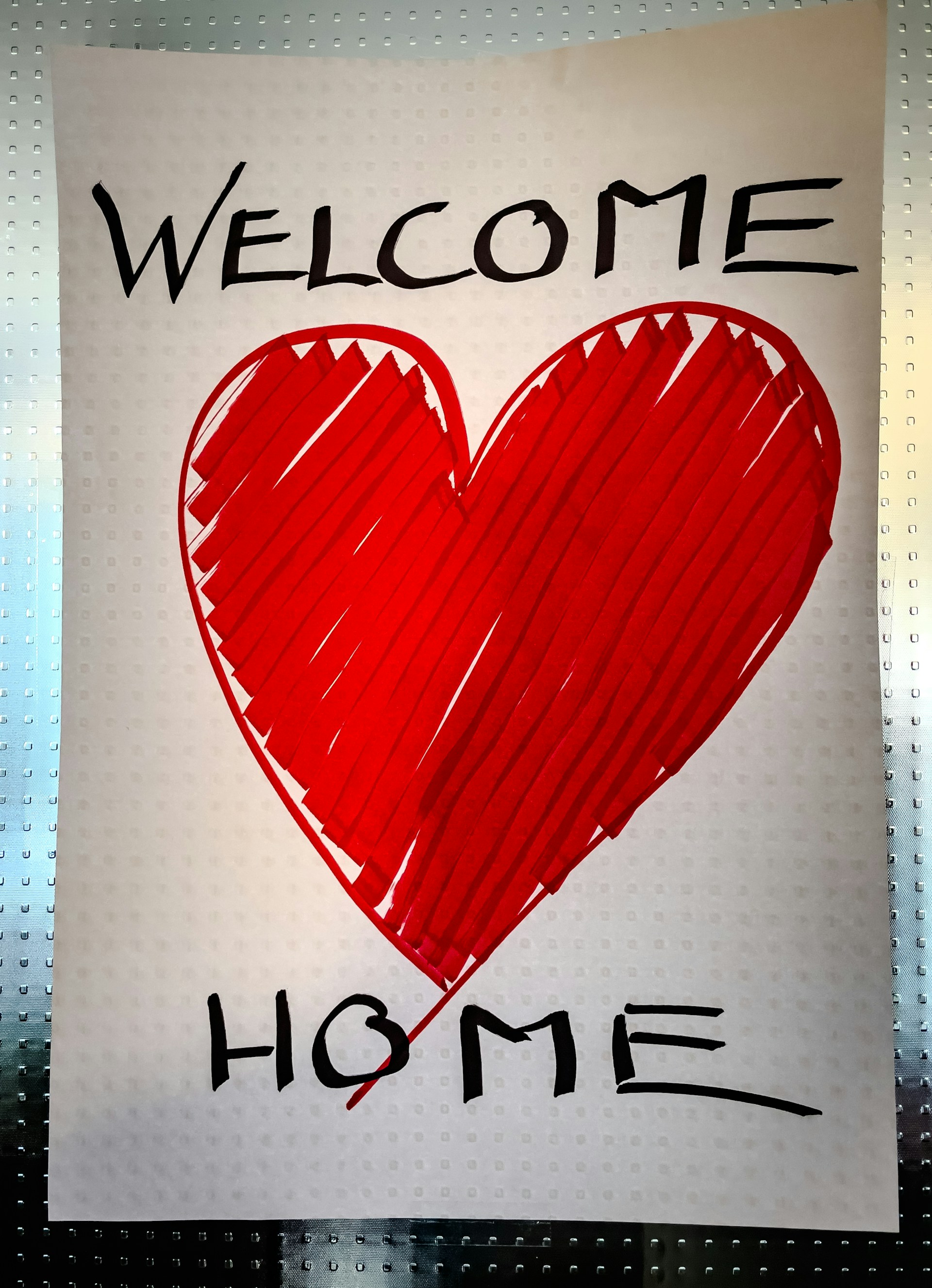 A sign that says welcome home with a heart drawn on it