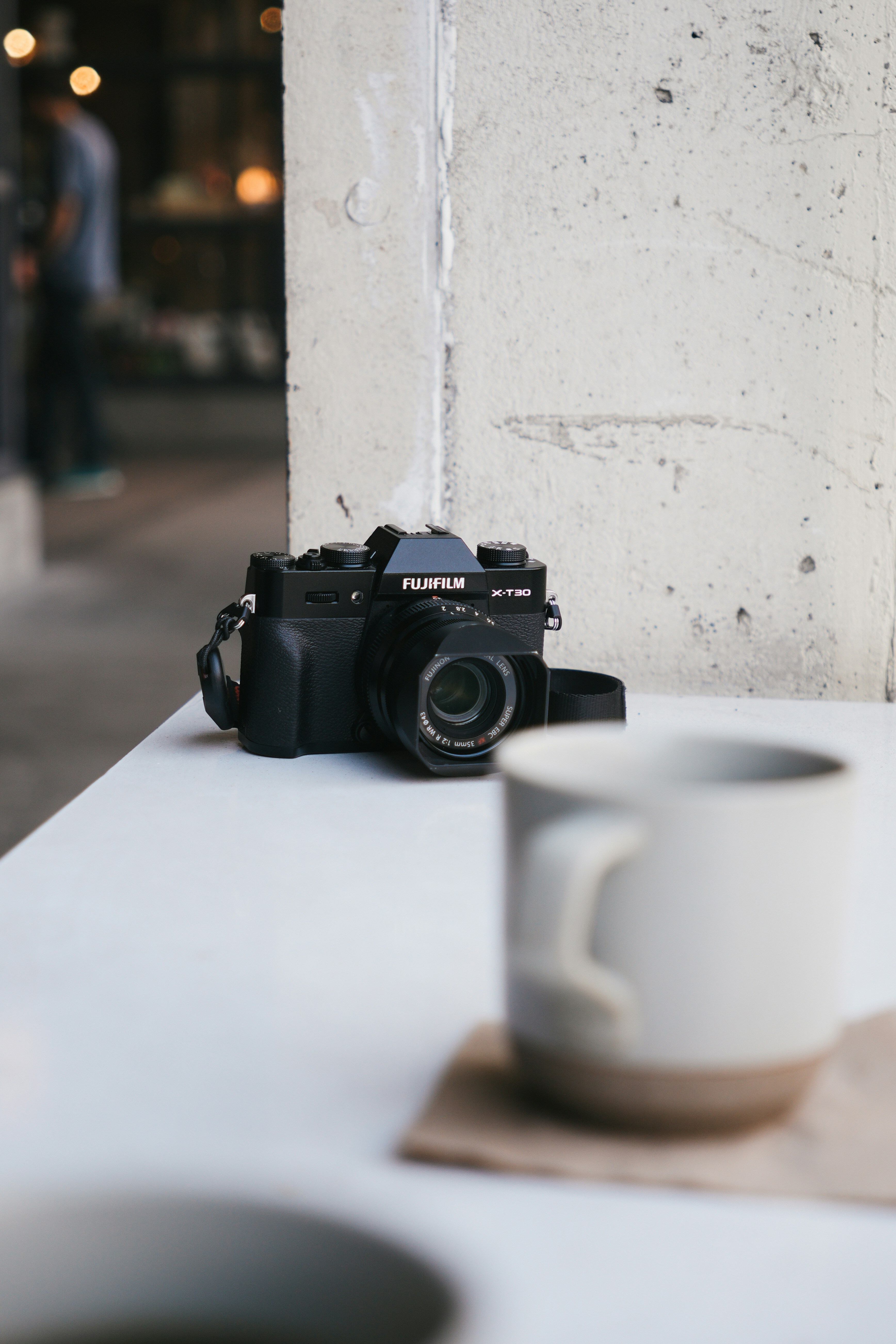 Eine Kaffeetasse und eine Kamera auf einem Tisch