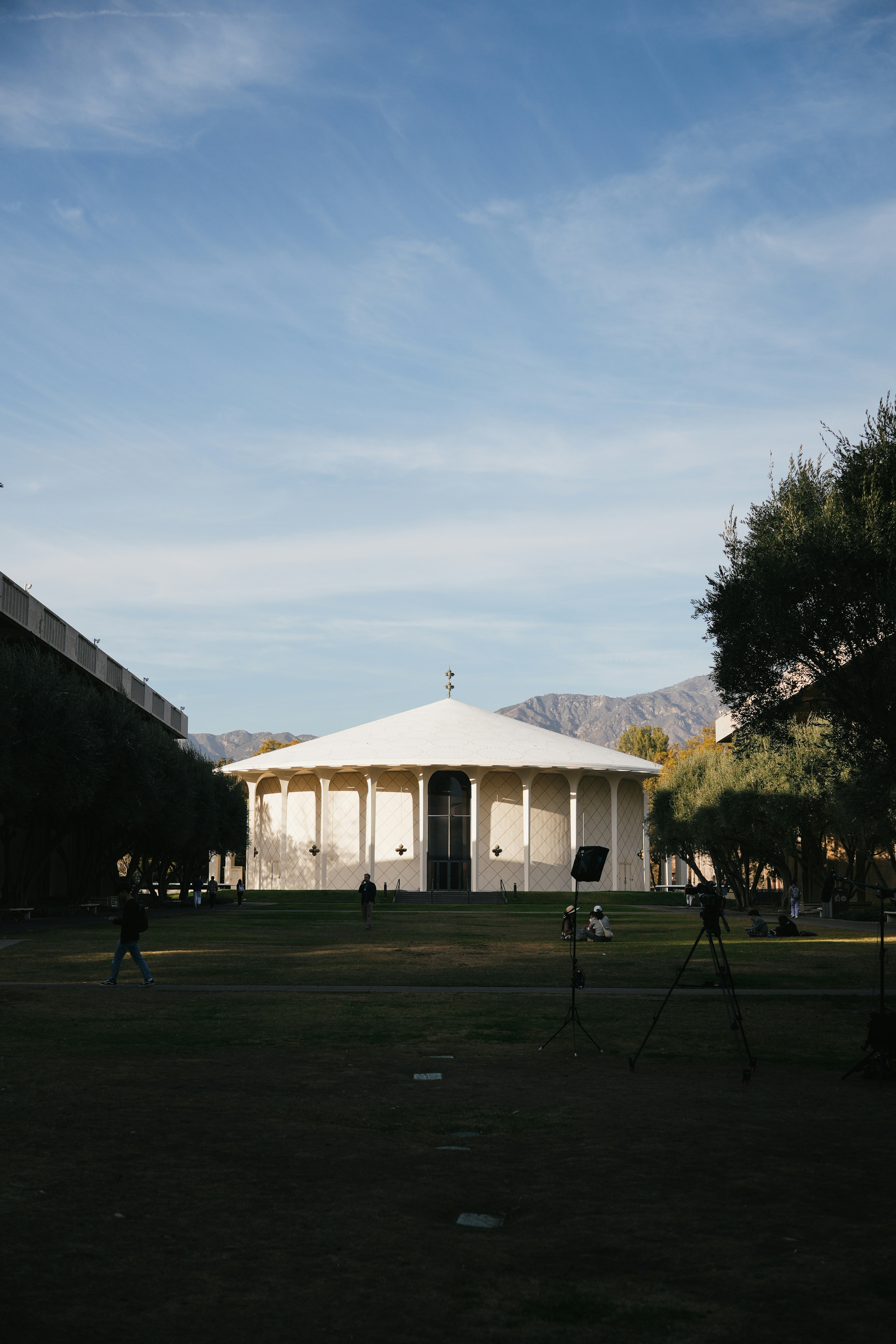 Ein großes Gebäude mit weißem Dach und ein paar Leuten, die davor stehen
